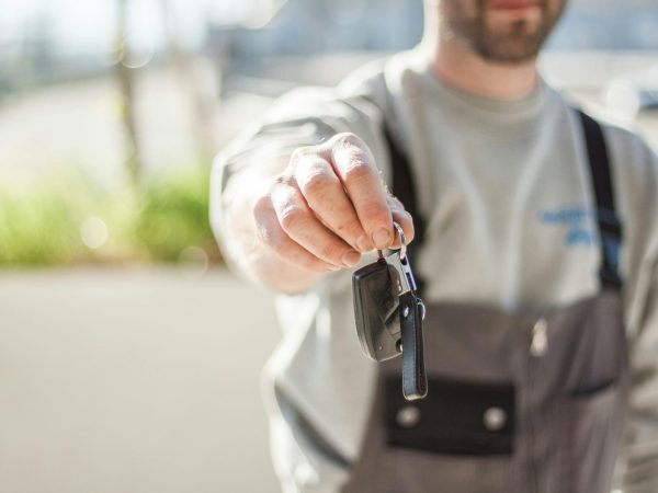 pexels-photo-97075-97075 Hand holding a car key outdoors, blurred background, shallow focus.